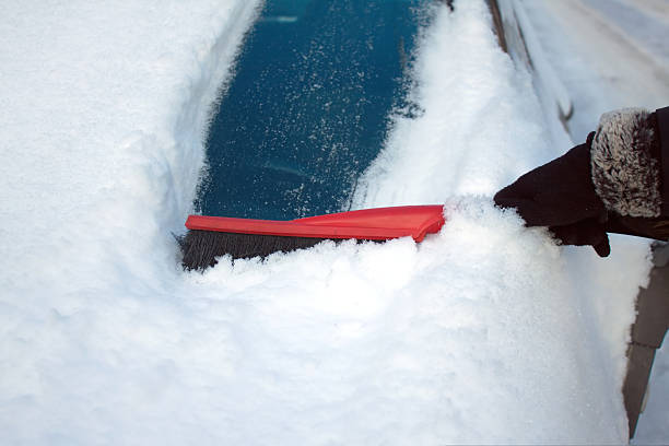 istock Woman brushing snow from a car 530538195