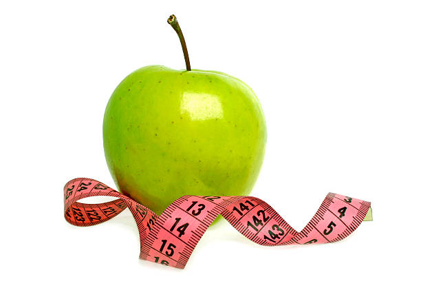 istock Diet concept - green apple and measuring tape 530547859