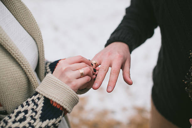 istock Bride putting wedding ring on groom's finger 530548755