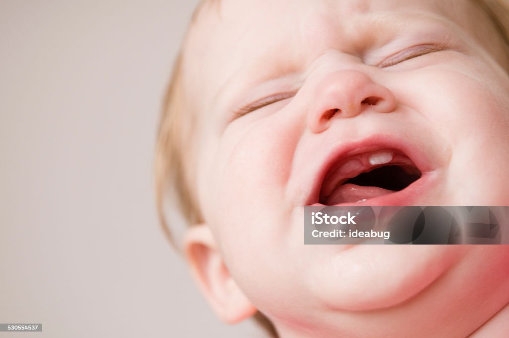 Crying Baby Suffering Through Pain of Teething Color photo of a crying baby suffering through the teething pain of new teeth coming in. Baby - Human Age Stock Photo