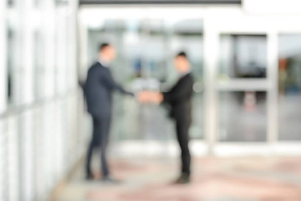 istock Blurred image of businessmen making handshake in front of office 530562748
