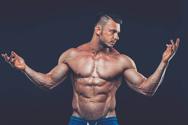 istock strong athletic man on black background 530563168