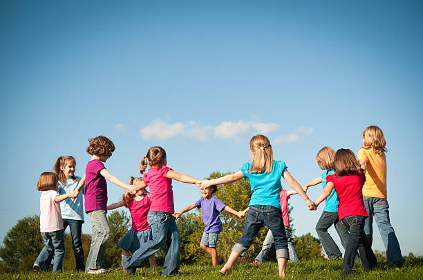 Group of Happy Girls Holding Hands in Circle Outside stock photo