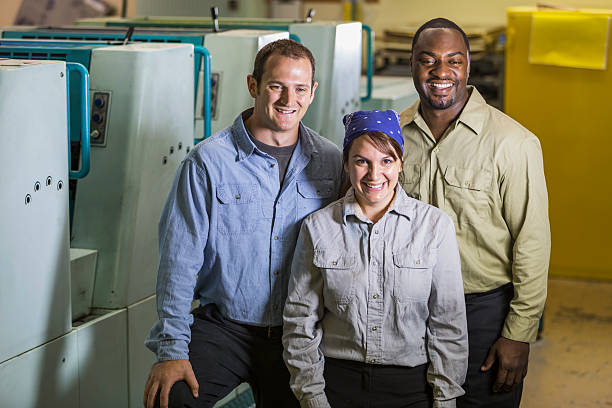istock Workers in manufacturing plant standing by machines 530566007