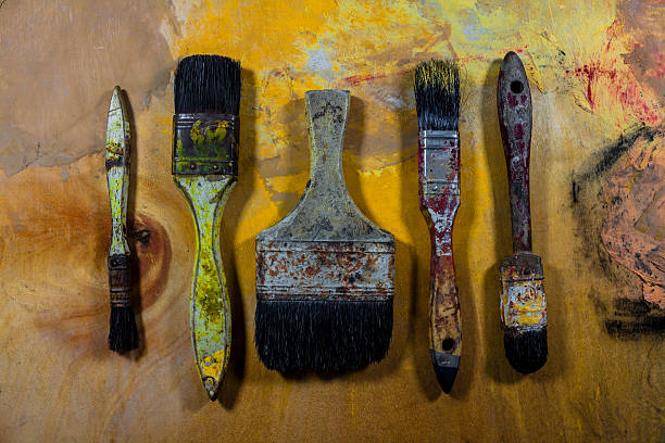 istock old grungy paint brushes on wood floor 530566210