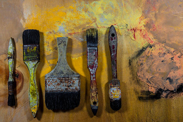 istock old grungy paint brushes on wood floor 530566262