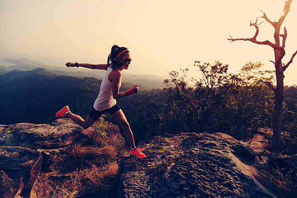 istock young asian woman runner running on mountain peak 530567018