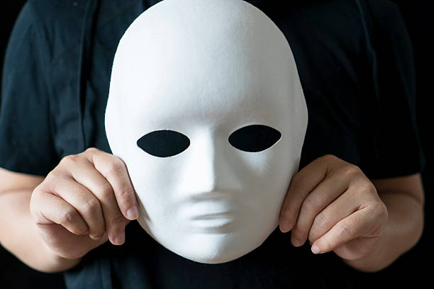 istock hand holding mask in black backgrounds 530567536