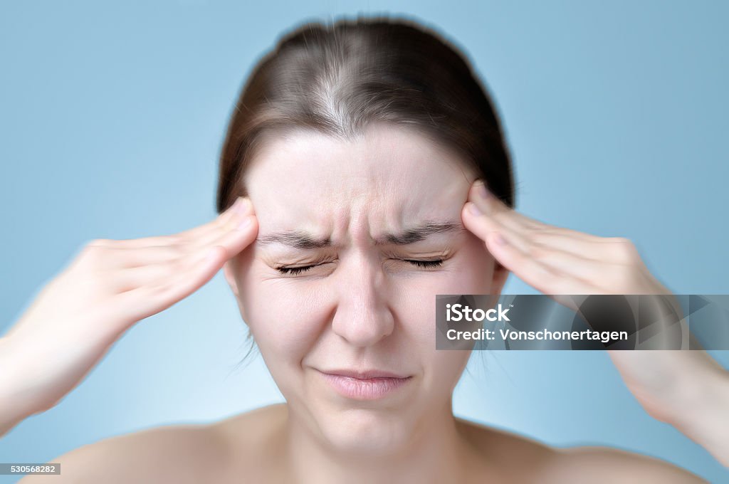 Woman suffering from headache Young woman touching her head Adult Stock Photo