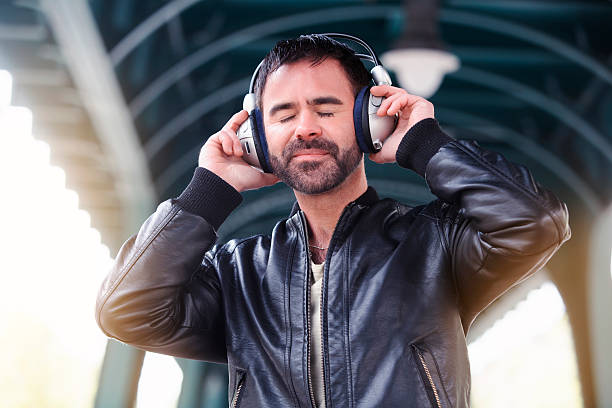 istock young man with headphones standing in the street 530568356