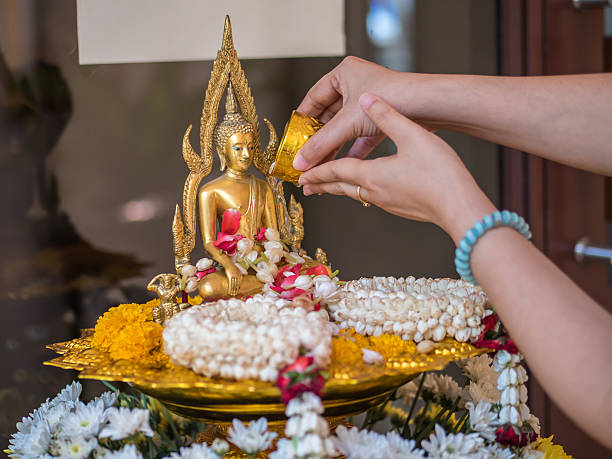 Pour water onto a Buddha statue stock photo