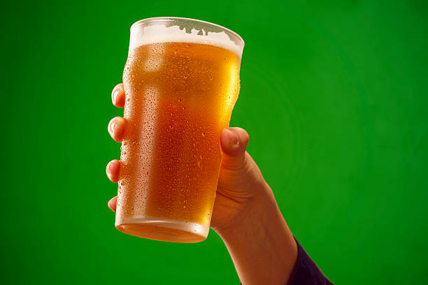 Cheers   Ice cold beer    Hand with beer glass making toast stock photo