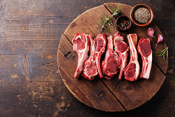 Raw fresh lamb ribs Raw fresh lamb ribs with pepper and cumin on wooden cutting board on dark background lamb meat photos stock pictures, royalty-free photos & images