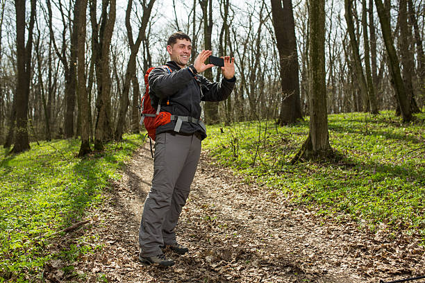 istock Hiking man take selfie during his walk through the forest 530571972
