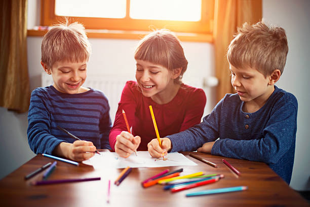 istock Sister and brothers enjoying drawing together 530578462