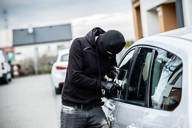 voleur de voiture à essayer de sortir de la voiture - cambriolage photos et images de collection