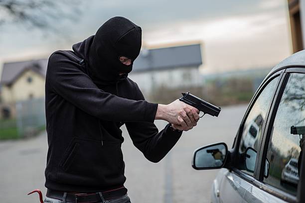 ladro di auto che indica una cartuccia del conducente - weapon burglary thief burglar foto e immagini stock