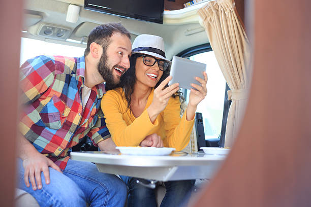 istock Cheerful couple using digital tablet inside of a camper 530580766