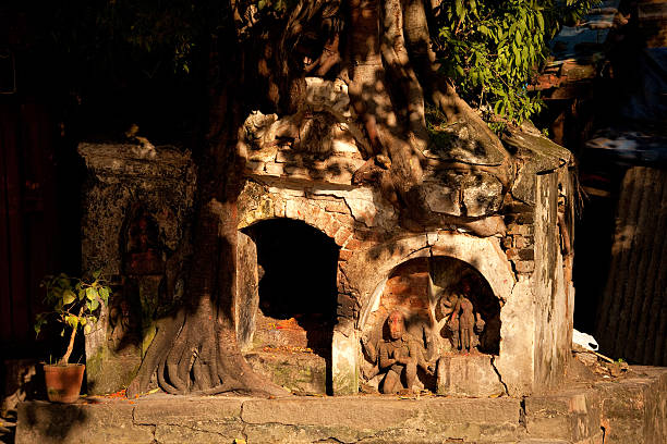 istock Small shrine covered in the roots of a tree. 530580819