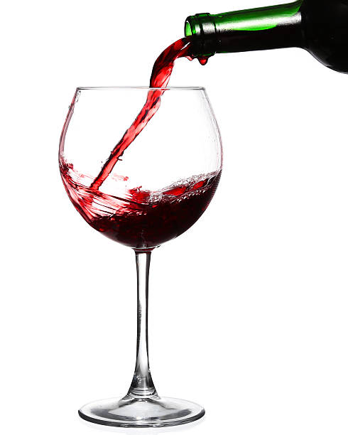 istock Red wine pouring on white background 530582301