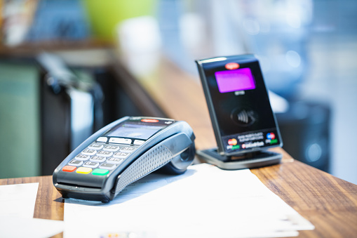Belgrade, Serbia - November 21, 2014: Credit card payment terminal with contactless payment (pay pass) device in background; selective focus, close up;