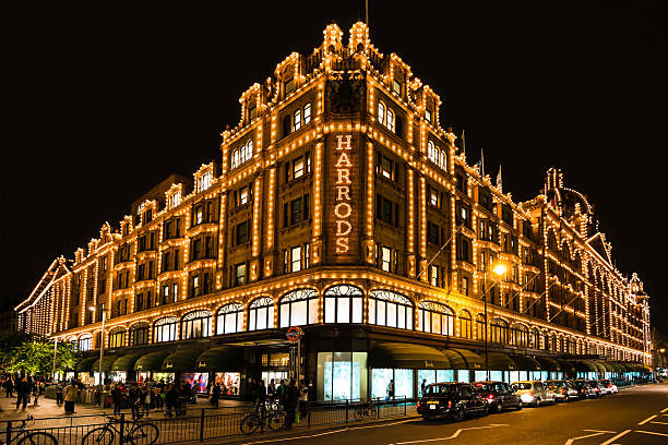Harrods department store in London at night London, United Kingdom - September 25, 2014: The famous Harrods department store in the evening of September 25, 2014 at Knightsbridge in London, UK. Harrods is the biggest department store in Europe and offers over one million square feet of retail space, acting as a magnet for rich clients and numerous tourists throughout the year. harrods photos stock pictures, royalty-free photos & images