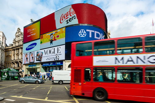 London, United Kingdom - September 26, 2014: A double decker bus and cars passing Piccadilly Circus with its neon signage advertising for companies like Coca Cola, TDK, Vogue, Samsung and Mc Donalds on September 26, 2014 in London, UK.
