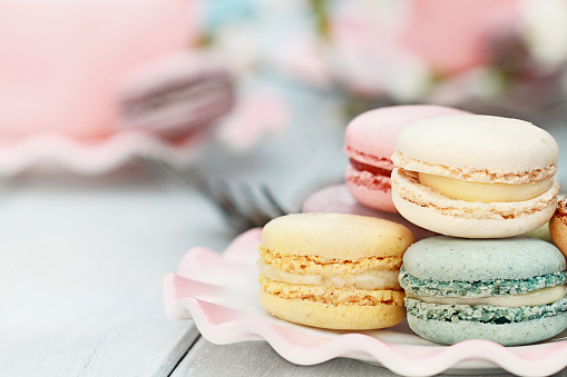 Saucer of fresh pastel colored macarons. Extreme shallow depth of field with selective focus on foreground.