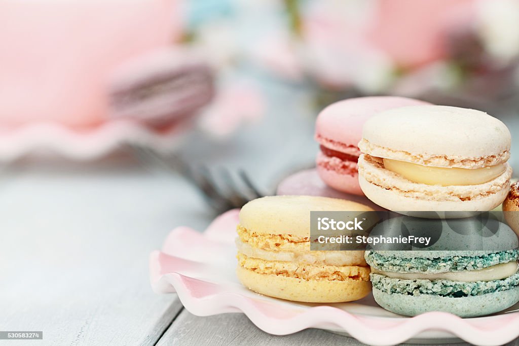 Sweet Pastel Colored Macarons Saucer of fresh pastel colored macarons. Extreme shallow depth of field with selective focus on foreground. Macaroon Stock Photo