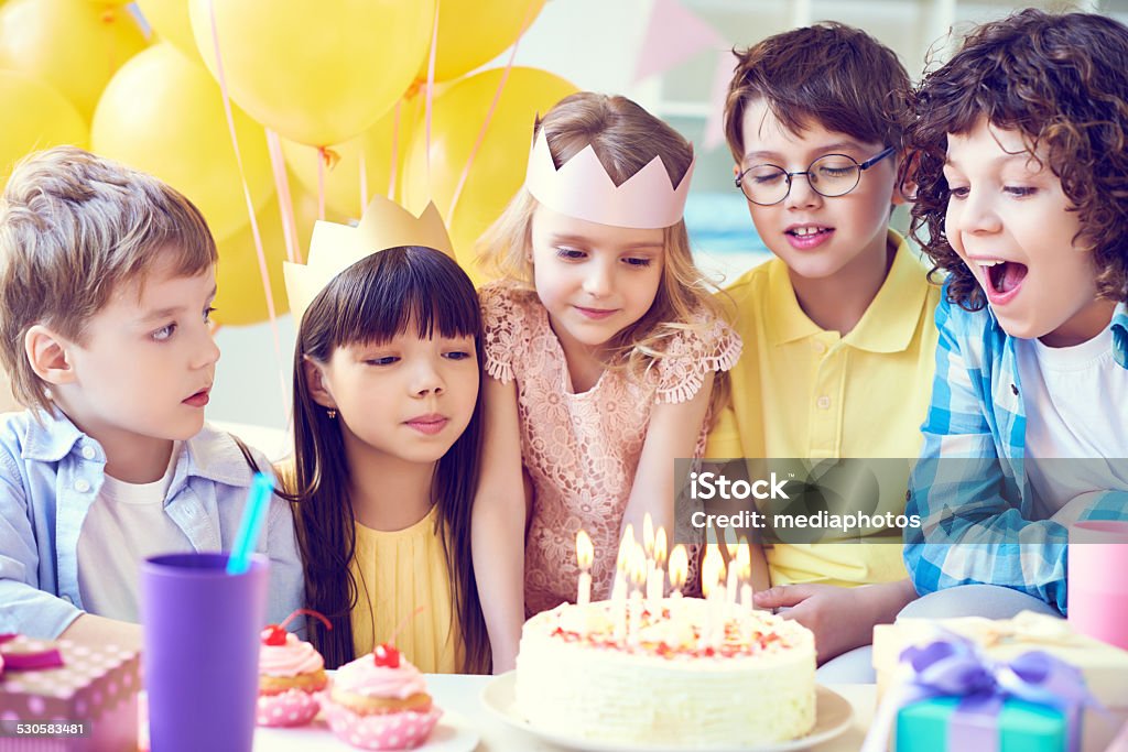 Ready for blowing out Kids preparing to blow out candles on birthday cake Balloon Stock Photo