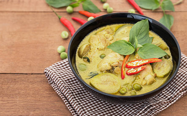 istock Thai chicken green curry with old wooden background 530583984