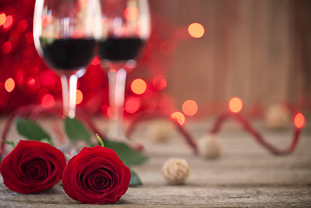 istock Valentine's day roses, red wine and old rustic wood table 530584977