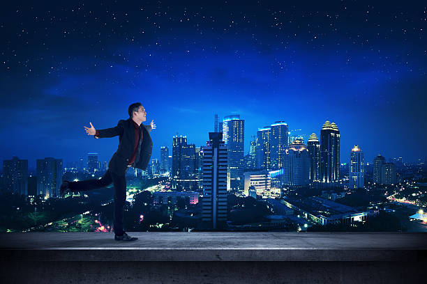 istock Successful business man on the rooftop at night time 530585422