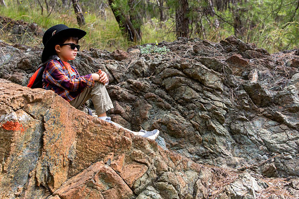 istock Boy Sitting On A Rock 530586194
