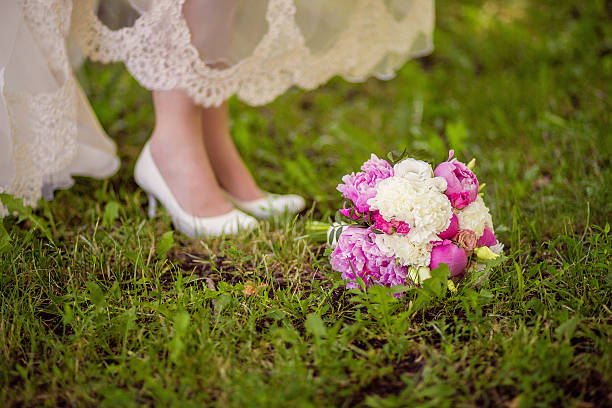 istock Bride's shoes and bouquet on the grass 530586564