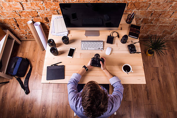 istock Photographer at the desk, office gadgets and object lens 530587398