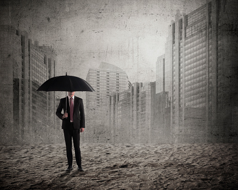 Asian business man holding umbrella over city background