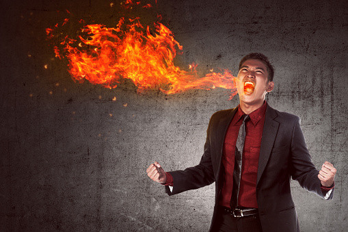 Image of young asian businessman in anger burning in flame