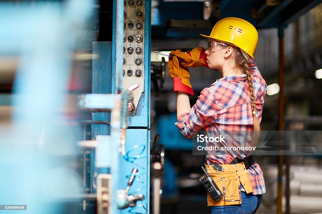 Young technician Young woman in uniform repairing something with screwdriver Electrician Stock Photo