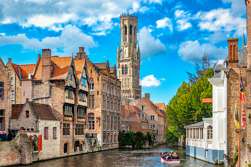 Belgium, Bruges - September 26, 2015: View from the Rozenhoedkaai in Bruges with the Perez de Malvenda house and Belfort van Bruges in the background and number of peoples in the boats.