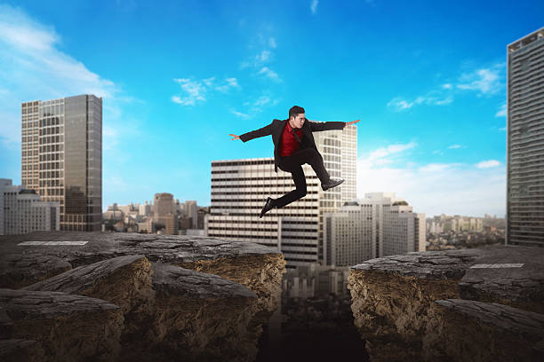 istock Asian business man jumping over broken road 530590160