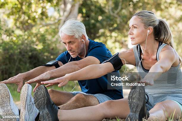 Couple Stretching At Park Stock Photo - Download Image Now - Exercising, Couple - Relationship, Relaxation Exercise