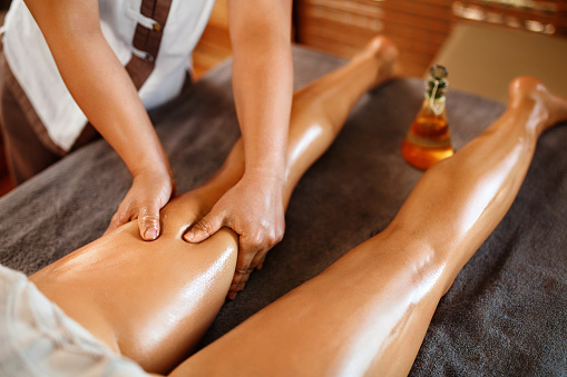 Spa Woman. Aromatherapy Oil Leg Massage Therapy. Masseur Massaging Sexy Young Long Female Legs In Cosmetology Salon. Beauty Treatment Concept. Relaxing Body Procedure. Skin Care, Wellness, Lifestyle