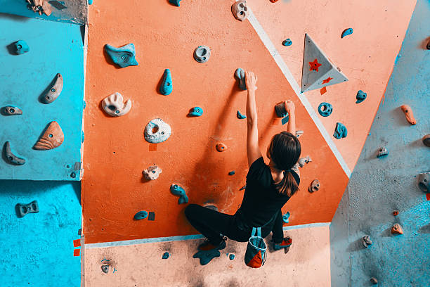 istock Woman climbing up on wall indoors 530606267