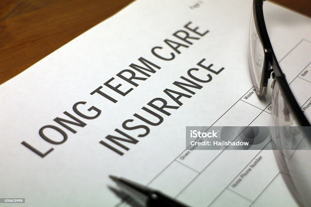 Medical Care Insurance Someone filling out Long Term Care Insurance Form. Body Care Stock Photo