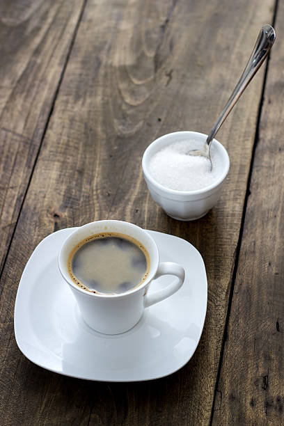 istock Cup of coffee with sugar on wooden table 530614821
