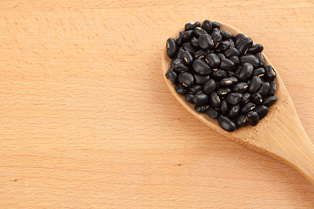 istock Black beans with wooden spoon 530615749