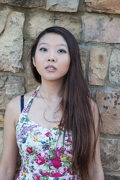 istock Asian woman by a stone wall 530617325