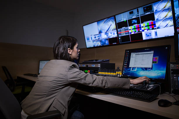 TV editor working with vision mixer in television broadcast gallery stock photo