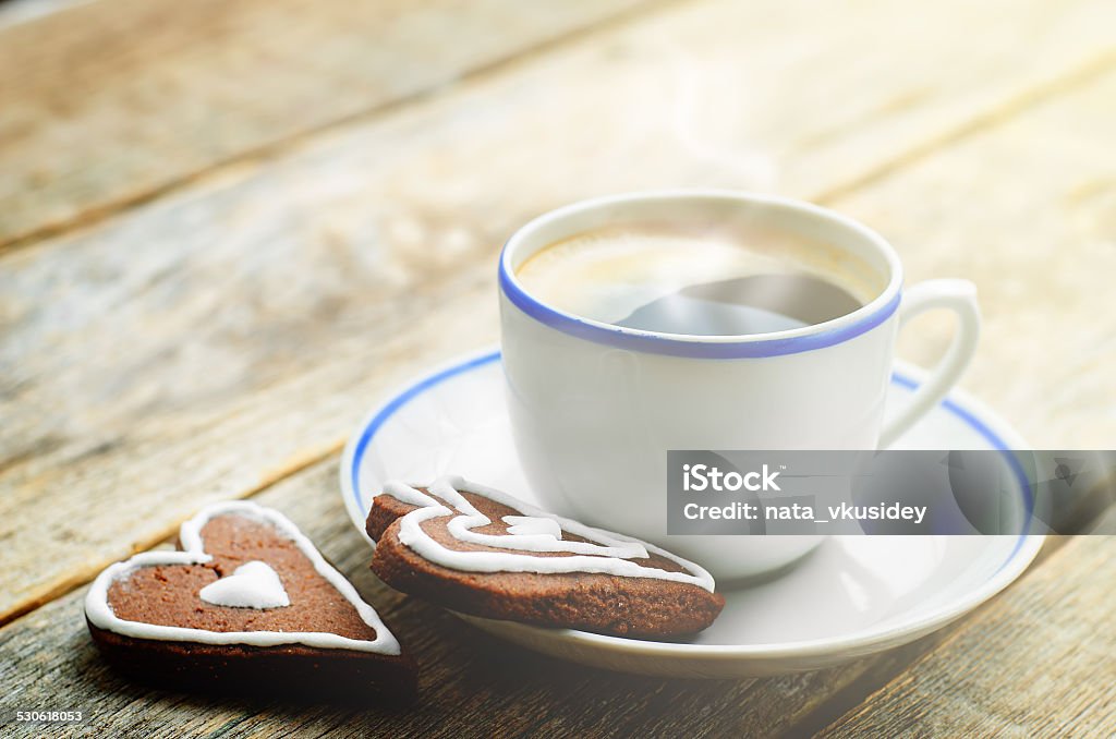 cup of coffee with the chocolate cookies cup of coffee with the chocolate cookies in the shape of a heart on a dark wood background. tinting. selective focus Aromatherapy Stock Photo